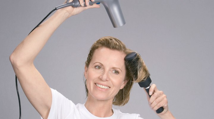 Blow dry hair over a round brush