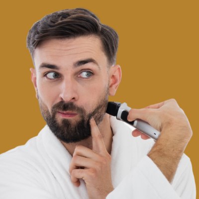 Man who is trimming his beard