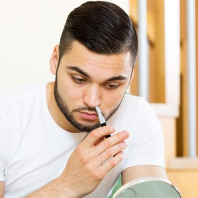 Man removing nose hair