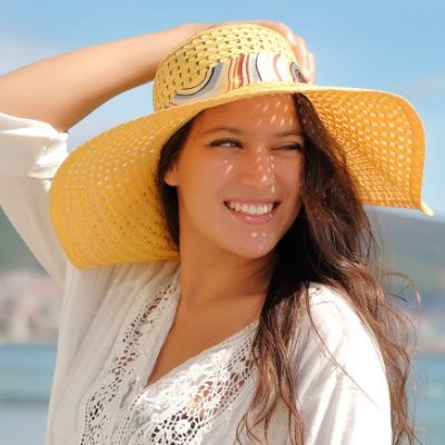 Woman wearing a summer hat to protect her hair