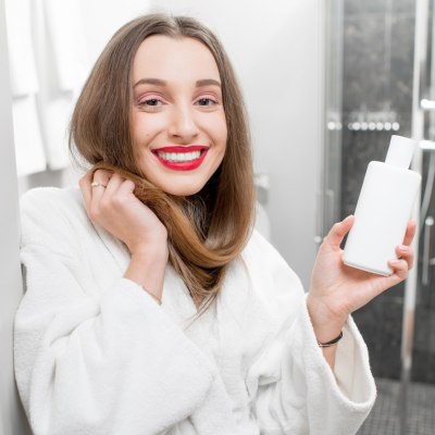 Woman with a bottle of shampoo