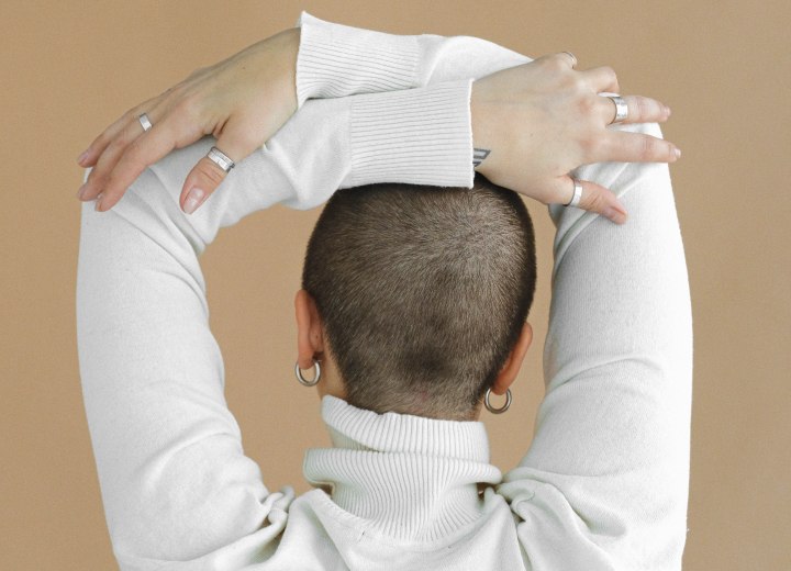 Woman who is wearing her hair very short in a buzz cut