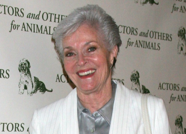 Lee Meriwether with silver hair and wearing a silk blouse
