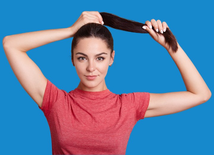 Woman who is pulling her hair up into a ponytail