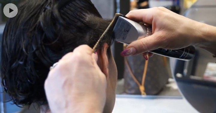 Clipper cutting the sides around the ears for a pixie