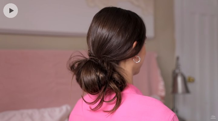 Hair styled into a messy low bun
